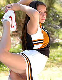 The cheerleader Michelle is outdoors modeling her hot body.